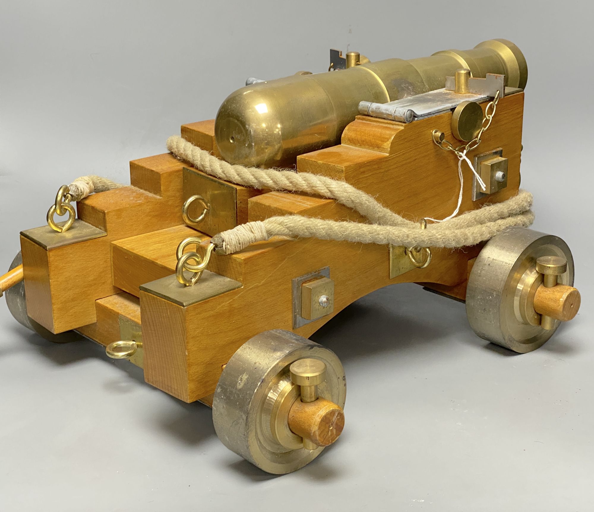 A bronze model of a cannon, on stepped wheel base with lion head motifs, length 50cm